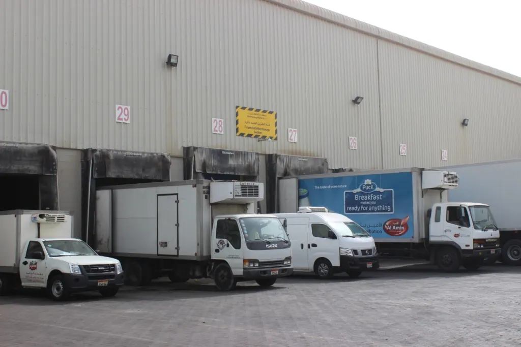 Refrigerated delivery trucks at a cold-chain loading dock in Bahrain